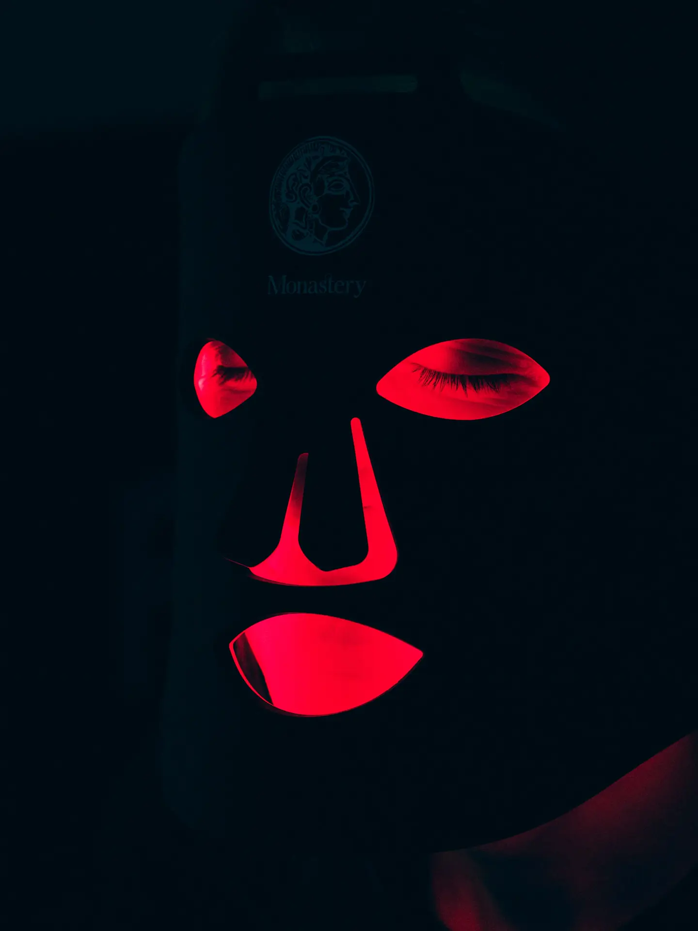 A person wearing the glowing Deep Red LED Mask